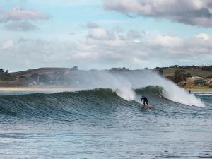 a person riding a wave on a surfboard in the ocean at Strawberry fields in Devonport