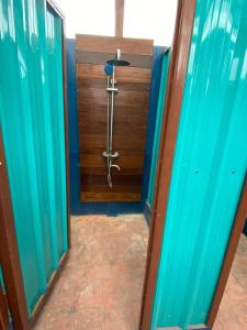 um quarto com um chuveiro e uma porta de madeira em TT Premium Hostel Vientiane em Vientiane