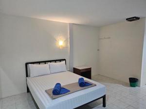 a bedroom with a bed with blue slippers on it at โรงแรมเมโทร2 Metro2 in Satun