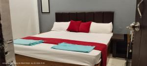 a bedroom with a large bed with red and white pillows at HOTEL AYODHYA PAYING GUEST in Ayodhya