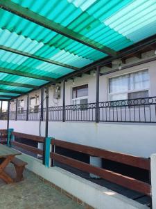awning on the side of a building with benches at Apartamentos Rosarito.!! Con Vista al Mar ! in Rosarito