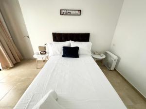 ein Schlafzimmer mit einem großen weißen Bett mit einem blauen Kissen in der Unterkunft Cómodo Apartamento Cerca Al Aeropuerto in Pereira