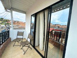 two chairs on a balcony with a view of a city at Cómodo Apartamento Cerca Al Aeropuerto in Pereira