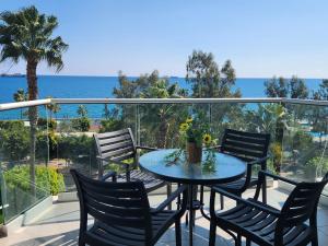 een tafel en stoelen op een balkon met uitzicht op de oceaan bij Luxurious Kalypso in Limassol