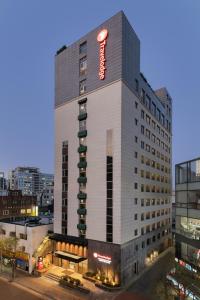 a tall building with a hotel sign on it at Travelodge Myeongdong Namsan in Seoul