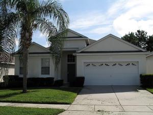 een wit huis met een garage en een palmboom bij Fan Palm Villa 8208 in Kissimmee