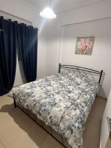 a bedroom with a bed with a floral comforter at Elena s apartment in Megara