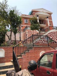 un camion rouge garé devant une maison avec des escaliers dans l'établissement Chovar homestay, à Kirtipur