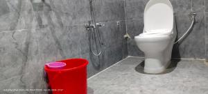 a bathroom with a toilet and a red trash can at HOTEL AYODHYA PAYING GUEST in Ayodhya