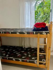 a bunk bed in a room with a window at Xixova Hostel Japui são Vicente in Praia Grande