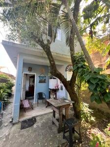 a house with a picnic table and a tree at Xixova Hostel Japui são Vicente in Praia Grande