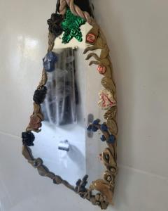 um espelho pendurado numa parede com conchas em Xixova Hostel Japui são Vicente na Praia Grande