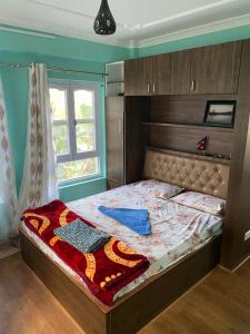 - une chambre avec un lit doté d'une tête de lit en bois et d'une fenêtre dans l'établissement Chovar homestay, à Kirtipur