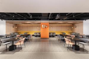 a dining room with tables and chairs and yellow walls at Travelodge Myeongdong Namsan in Seoul