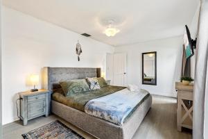 een slaapkamer met een groot bed en een nachtkastje bij Gorgeous open concept 4 BR with heated pool and lounge area in Fort Lauderdale