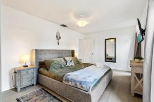 a bedroom with a large bed and a night stand at Gorgeous open concept 4 BR with heated pool and lounge area in Fort Lauderdale