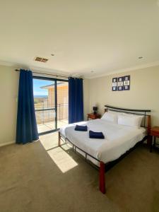 a bedroom with a bed and a large window at Port Denison Beach Resort in Port Denison