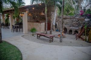 a patio with a bench and a fire place at Casa Cactus Buenavista in Bacalar