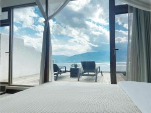 a bedroom with a bed and a view of the ocean at Dali Dare Sea View Gueshouse in Dali