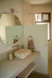 a bathroom with a stone sink and a mirror at Casa Cactus Buenavista in Bacalar