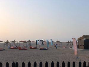 a playground on a beach with a fence at Residence Casa Bay Sidi Rahal in Sidi Rahal