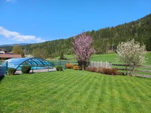 einen Hof mit einem Zaun und einem Feld mit Bäumen in der Unterkunft Ferienhaus Helmuth Oberreiter in Flachau