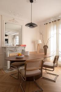 comedor con mesa, sillas y espejo en Parisian Luxury at Etienne Pernet, en París