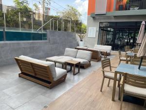 un patio con sillas, mesas y una piscina en Apartamento 2 Habitaciones, Edificio EON, Zona 10, Turin, en Guatemala