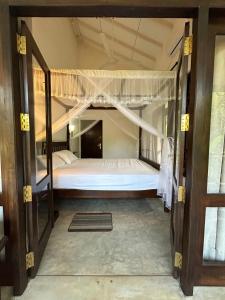 una puerta abierta a un dormitorio con litera en White Villa Goyambokka, en Tangalle