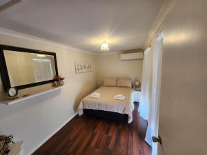 a small bedroom with a bed and a window at Roseneath Cottage in Northam