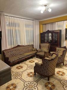 een woonkamer met een bed, een bank en stoelen bij Lima ciudad de los reyes in Lima
