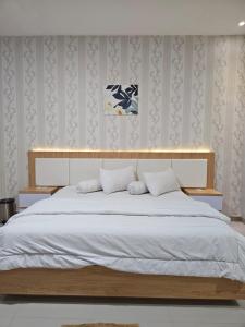 a bedroom with a large bed with white sheets at LOSMEN 88 in Ratodena