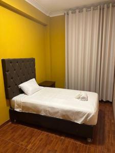 een slaapkamer met een bed in een kamer met gele muren bij Lima ciudad de los reyes in Lima