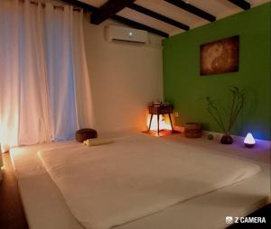 a bedroom with a white bed with a green wall at Wilma in Čavle