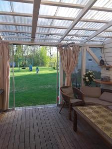 a screened in porch with a couch and a table at Домик для двоих in Pärnu