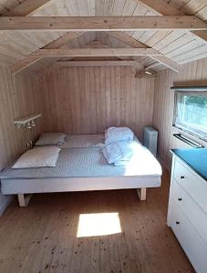 uma cama num quarto com piso em madeira em Cozy Cottage Nearby Great Sandy Beach em Højby
