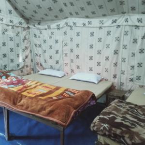 a room with two beds in a tent at GREEN VALLEY CAMPING & ADVENTURE in Nainital