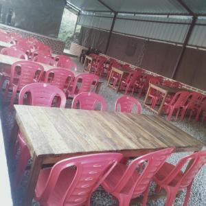 a group of pink chairs around a wooden table at GREEN VALLEY CAMPING & ADVENTURE in Nainital