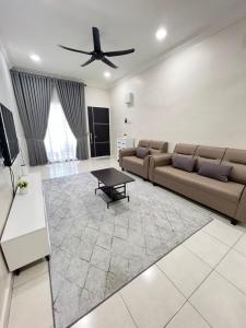 uma sala de estar com um sofá e uma mesa em SAFRA HOMESTAY PERLIS em Arau