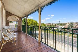 a balcony with chairs and a view of the street at The White House - Heritage Style Terrace in Molong