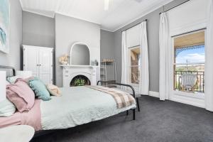 a bedroom with a bed and a fireplace at The White House - Heritage Style Terrace in Molong