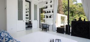 sala de estar con paredes blancas y ventana grande en Villa Belle, en Choeng Mon Beach