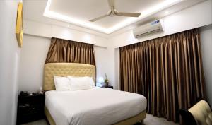 um quarto de hotel com uma cama e uma ventoinha de tecto em Xpressmall Hotel near Dhaka Airport em Dhaka mais 32 fotografias
