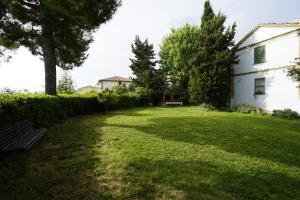a yard with a bench in front of a white house at B&B Chalet tra le vigne in Atri
