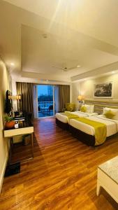 プネにあるAmanora The Fern Hotels & Clubのウッドフロアのホテルルーム内のベッド2台