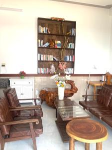 sala de estar con sofá, sillas y mesa en Dứa Homestay, en Bao Loc