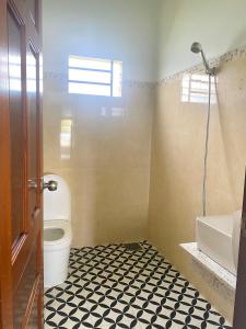 y baño con aseo, bañera y lavamanos. en Dứa Homestay, en Bao Loc