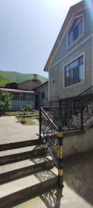 a house with a staircase in front of a building at Ilham Mustafa Houses in Sheki