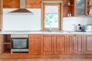 eine Küche mit Holzschränken und Spüle und einem Fenster in der Unterkunft Casita de madera in Benicarló + 24 Fotos