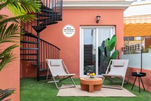 two chairs and a table in front of a house at Suites Maestranza - Santas Patronas by Magno Apartments in Seville +18 photos
